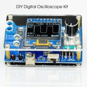 May include: A DIY digital oscilloscope kit with a blue circuit board, a small screen displaying a waveform, and a black knob. The kit includes various electronic components and is encased in a clear acrylic housing. The text "DIY Digital Oscilloscope Kit" is at the top.