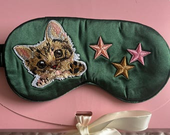 Handmade silk eye mask with cat motif .