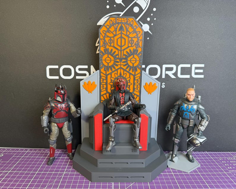 May include: Three action figures from a science fiction franchise. One figure is seated on a throne with an orange and gray design. The other two figures are standing, one in red and gray armor, the other in black and blue armor.