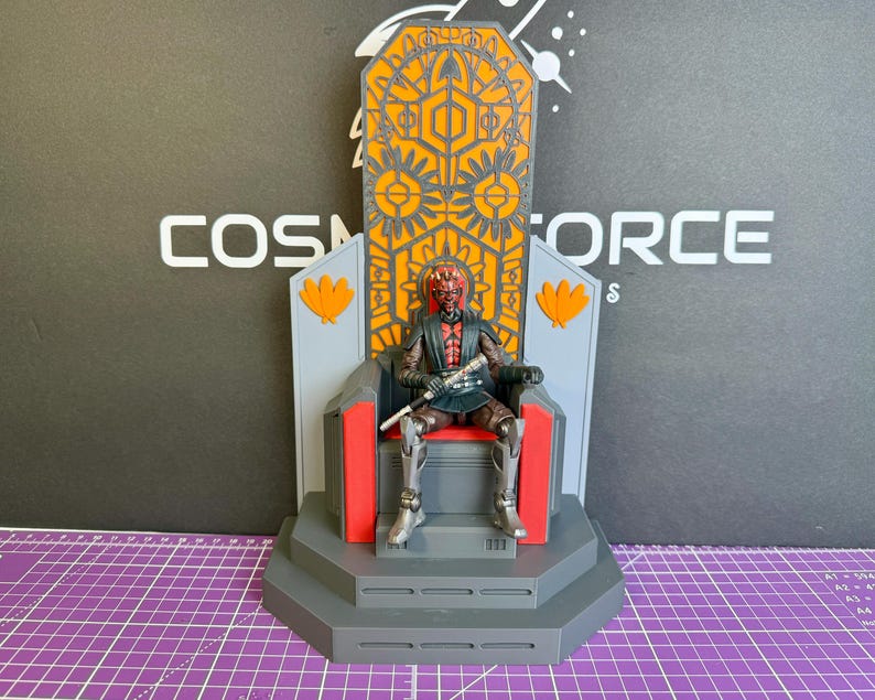 May include: A detailed action figure of Darth Maul seated on a throne. The throne is gray, red, and orange with intricate geometric designs. The figure is holding a lightsaber. The background features the text "COSMOS FORCE".