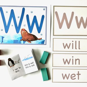 Puede incluir: Un conjunto de tarjetas educativas para aprender la letra W. Las tarjetas presentan una W mayúscula azul, una w minúscula marrón y las palabras "will", "win" y "wet". También hay un pequeño libro con un pingüino y las palabras "I ran to Win." y "Win is wet. Win is sad."