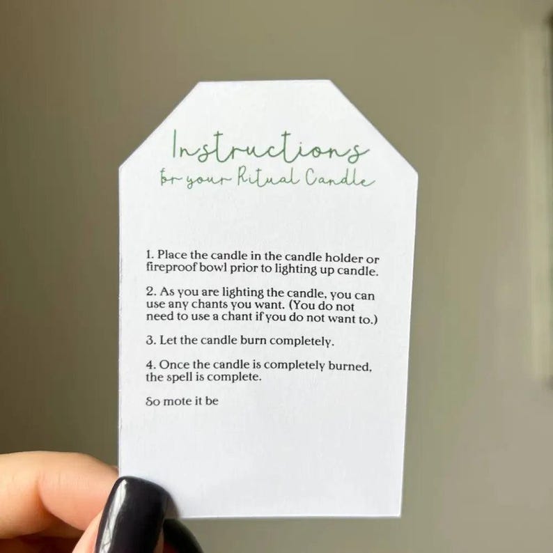 White paper tag with green ritual instructions for Medusa candles