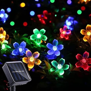 May include: A solar powered string of lights with colorful flower shaped bulbs. The lights are strung on a wire and are powered by a solar panel.