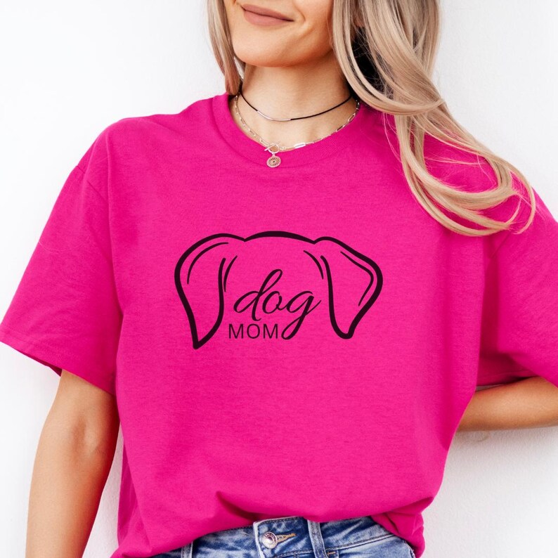 T-Shirt featuring a minimalist design with dog ears and the phrase 'dog MOM' in cursive, perfect for dog lovers who want to showcase their love for their pets in a stylish and comfortable way.