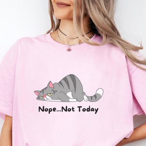 Close-up of cat lover sweatshirt highlighting soft fabric, high-quality print, and playful cartoon cat illustration with sarcastic message.  A t-shirt with a cartoon gray cat lying down with the text 'Nope...Not Today' printed below the cat.