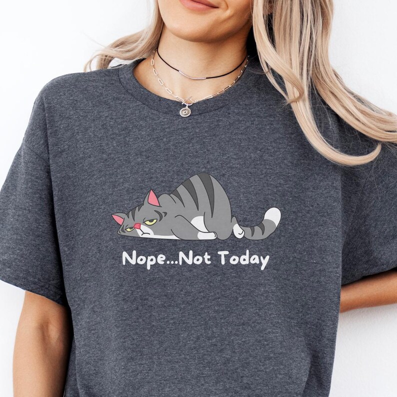 May include: A t-shirt with a cartoon gray cat lying down with the text 'Nope...Not Today' printed below the cat.