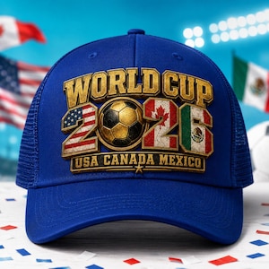 May include: A royal blue baseball cap featuring a gold-toned 3D graphic that reads WORLD CUP 2026 USA CANADA MEXICO. The design incorporates a soccer ball in the center and the flags of the United States, Canada, and Mexico within the numbers.