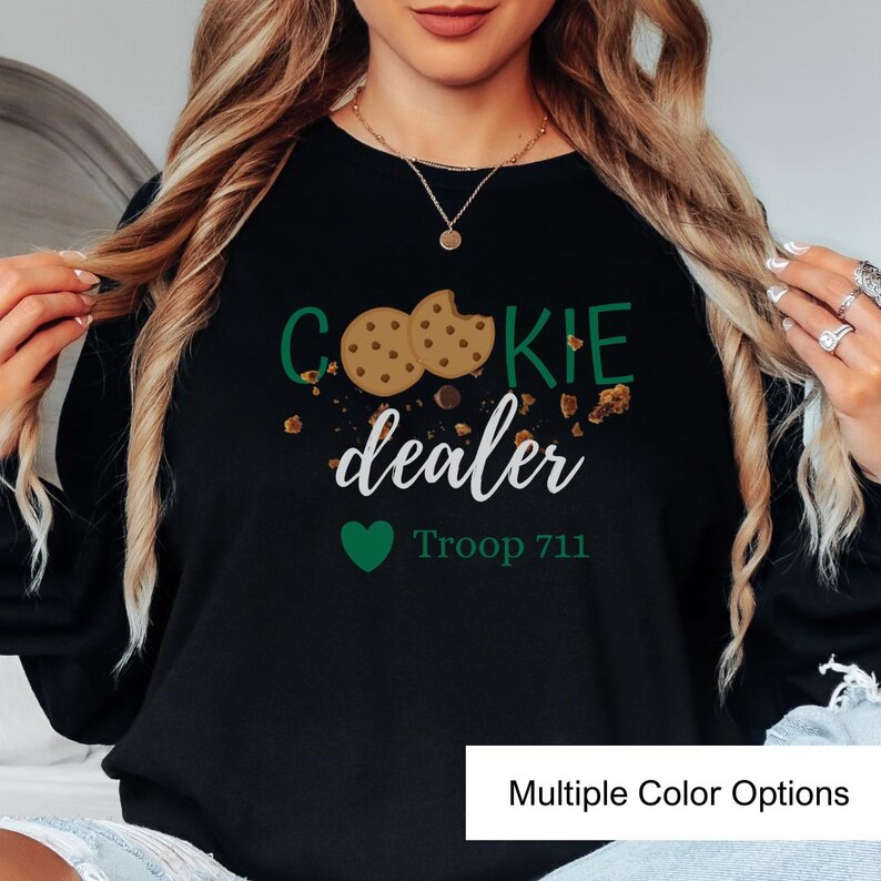 Girl Scout troop sweatshirt featuring cookie dealer text and cookie crumbs design. Fun and comfortable crewneck designed for scouts, leaders, and proud cookie sellers.