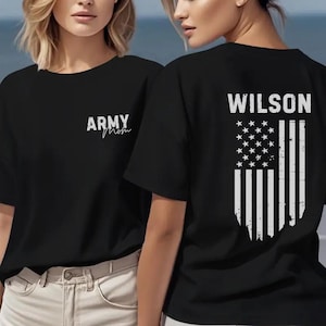 May include: Black t-shirts with white text and graphics. One shirt has "ARMY Mom" in script on the front. The other shirt has "WILSON" above a distressed American flag design on the back.