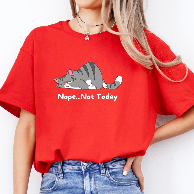 May include: A t-shirt with a cartoon gray cat lying down with the text 'Nope...Not Today' printed below the cat.