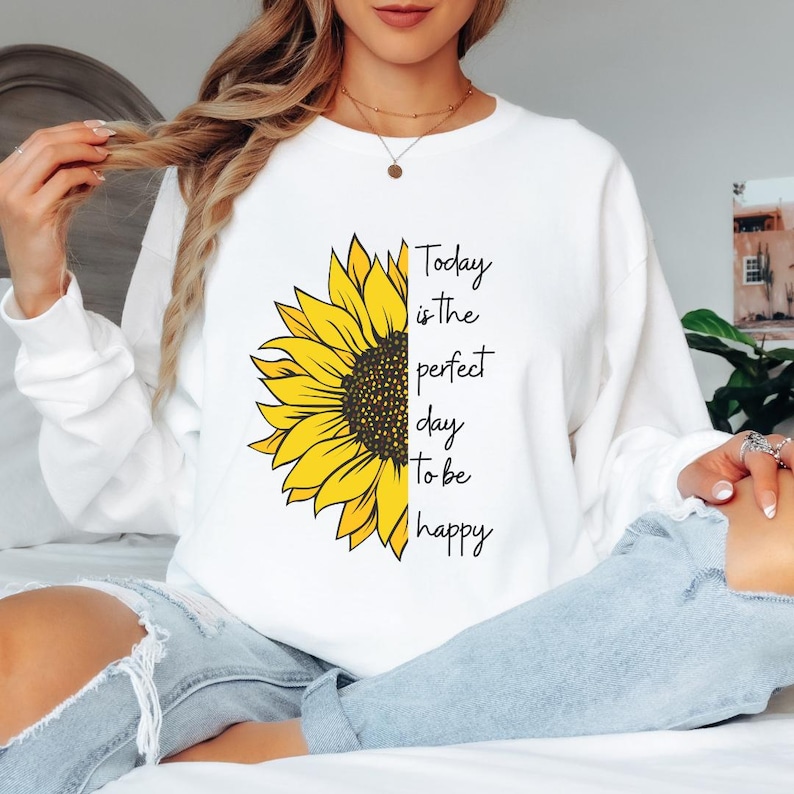 Happy quote sweatshirt featuring sunflower design and uplifting message printed on a soft crewneck. Great for positive vibes, casual outfits, and meaningful gift ideas.