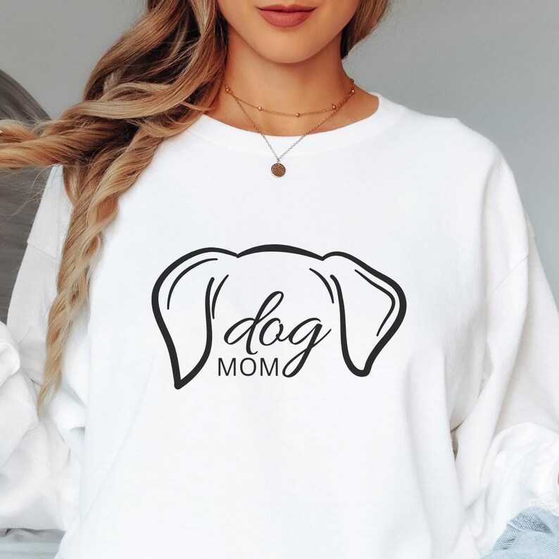 Sweatshirt featuring a minimalist design with dog ears and the phrase 'dog MOM' in cursive, perfect for dog lovers who want to showcase their love for their pets in a stylish and comfortable way.