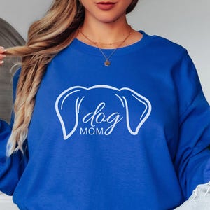 Sweatshirt featuring a minimalist design with dog ears and the phrase 'dog MOM' in cursive, perfect for dog lovers who want to showcase their love for their pets in a stylish and comfortable way.