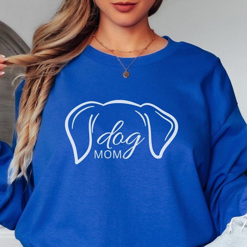 Sweatshirt featuring a minimalist design with dog ears and the phrase 'dog MOM' in cursive, perfect for dog lovers who want to showcase their love for their pets in a stylish and comfortable way.