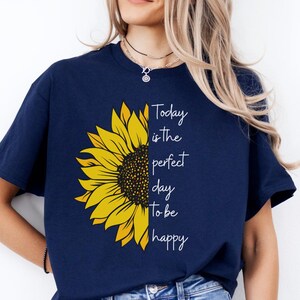 May include: A t-shirt with a yellow sunflower graphic and the text 'Today is the perfect day to be happy'.