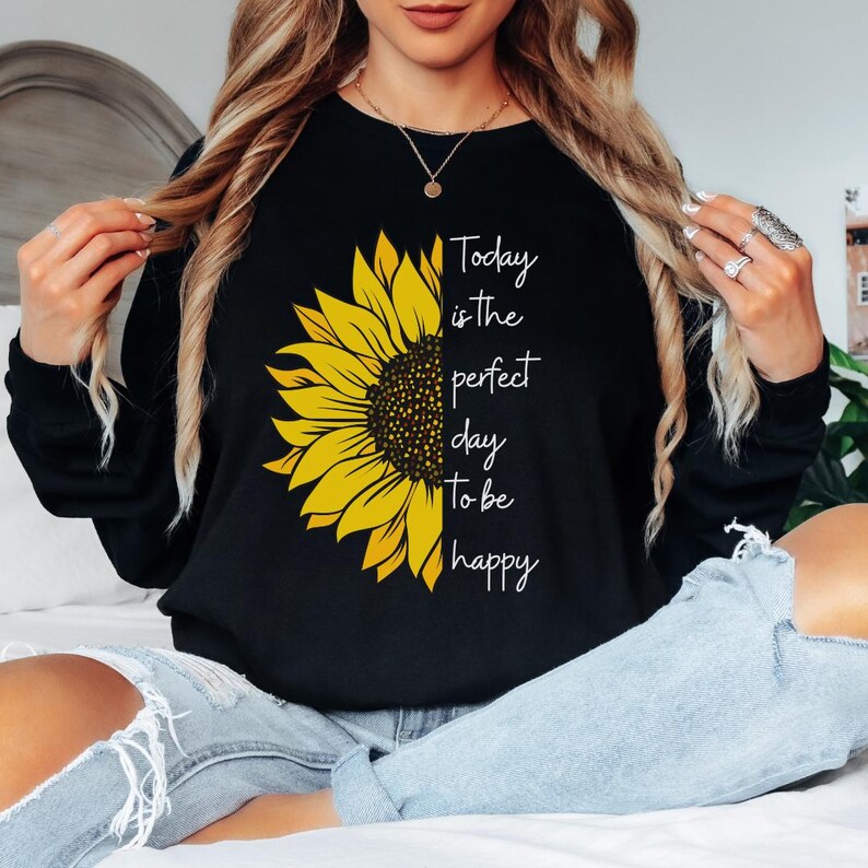 May include: A sweatshirt with a yellow sunflower graphic and the text 'Today is the perfect day to be happy'.