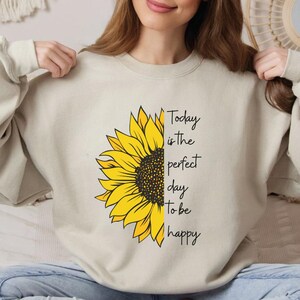 Inspirational sunflower sweatshirt featuring floral design and uplifting quote printed on a comfortable crewneck. Ideal for casual wear, positive mindset outfits, and stylish everyday fashion.
