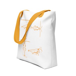 May include: White canvas tote bag with orange straps. The bag features a line drawing of a cherry shrimp with measurements in millimeters. The text "Cherry Shrimp Neocaridina davidi" is printed on the bag.