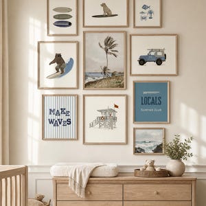 May include: A collection of framed art prints with a coastal theme. The prints feature illustrations of surfboards, a dog surfing, a bear surfing, a blue jeep with a surfboard, a lifeguard tower, and ocean scenes. The text "MAKE WAVES" and "LOCALS SURFING CLUB" are also displayed.