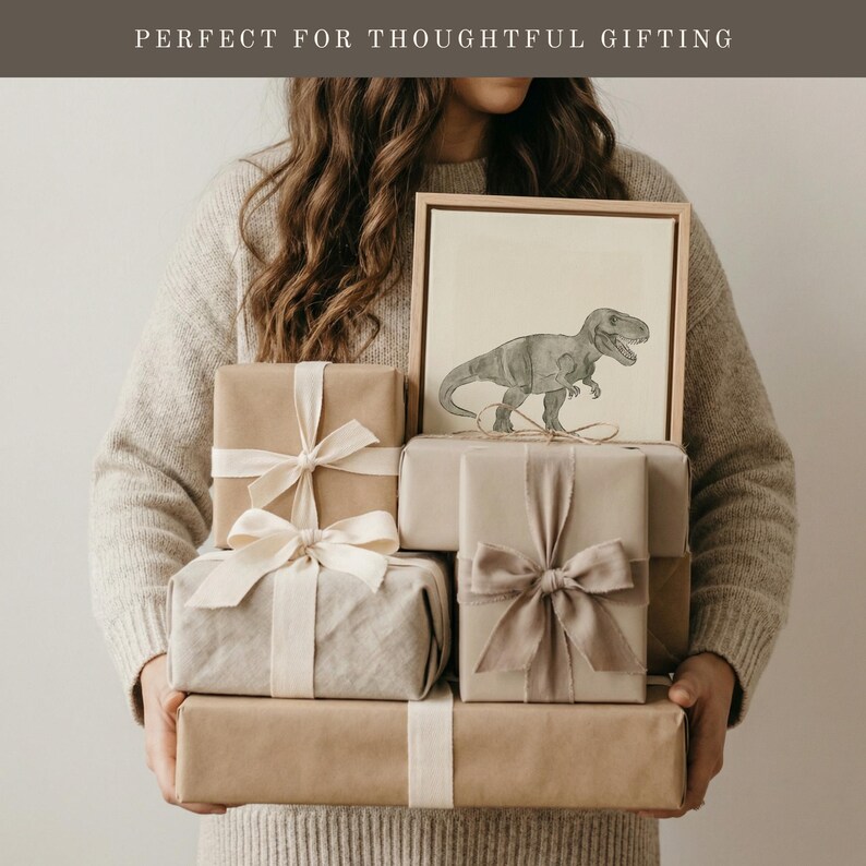 May include: A stack of wrapped gifts in various sizes and shades of brown, tied with cream-colored ribbons. A framed dinosaur drawing sits atop the gifts. The text "PERFECT FOR THOUGHTFUL GIFTING" is at the top of the image.