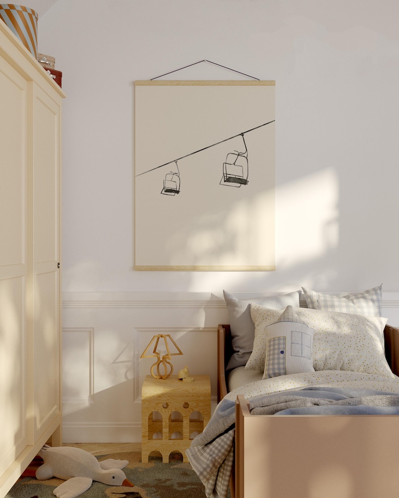 May include: A framed print with a minimalist line drawing of two ski lift chairs on a cable. The artwork is displayed on a light background, adding a touch of modern decor to a bedroom. The print is hung with wooden bars, creating a simple, elegant look.