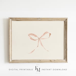 May include: A framed print of a watercolour painting of a pink ribbon tied into a bow.