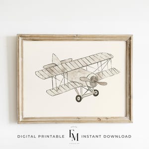 Peut inclure: Une illustration aquarelle en noir et blanc d'un avion vintage dans un cadre en bois clair. L'avion est dessiné dans un style simple avec quelques détails, comme l'hélice et les roues. L'image est parfaite pour une chambre d'enfant ou une crèche.