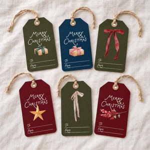 Può includere: Sei etichette regalo rettangolari con cordini in juta. I disegni includono la scritta Merry Christmas, pacchetti regalo, un nastro rosso, una stella dorata, un nastro beige e bacche rosse, con linee per To e From in basso.