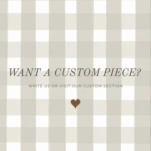 Pu&ograve; includere: Immagine quadrata con sfondo a motivo a scacchi grigio chiaro e bianco. Il testo "WANT A CUSTOM PIECE?" &egrave; visualizzato in un carattere marrone scuro. Sotto il testo c'&egrave; la frase "WRITE US OR VISIT OUR CUSTOM SECTION". Un cuore marrone in basso.