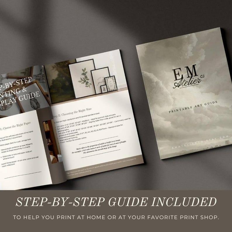 May include: A printed art guide with a soft, cloudy cover and open pages. The guide includes step-by-step instructions for printing and displaying art. The cover features the text "EM Atelier" and "Printable Art Guide."