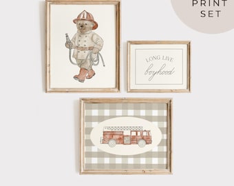 Op de afbeelding: Een set van drie ingelijste prints. Eén toont een beer als brandweerman, een andere leest "LONG LIVE boyhood", en de derde toont een rode brandweerwagen op een geruite achtergrond. De prints zijn gelabeld met "3 PRINT SET".