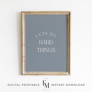 Puede incluir: Una impresión enmarcada con un fondo azul claro y texto blanco que dice "Puedo hacer cosas difíciles".