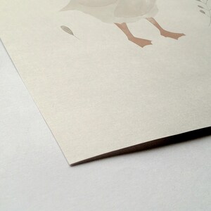 Peut inclure: Illustration &agrave; l'aquarelle d'une oie avec des pattes marron clair et un corps gris clair. Une petite plume grise et un brin de feuilles sont &eacute;galement visibles. L'&oelig;uvre est sur papier textur&eacute; blanc cass&eacute;.