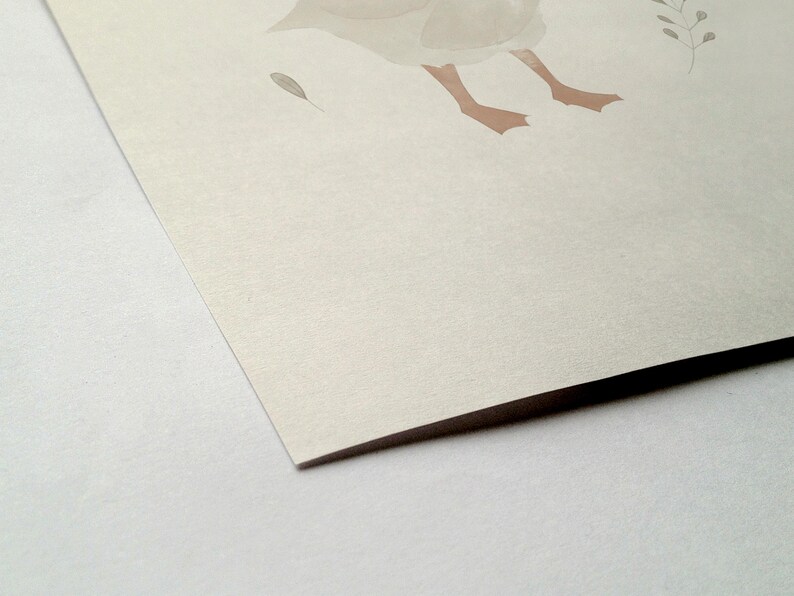 Peut inclure: Illustration &agrave; l'aquarelle d'une oie avec des pattes marron clair et un corps gris clair. Une petite plume grise et un brin de feuilles sont &eacute;galement visibles. L'&oelig;uvre est sur papier textur&eacute; blanc cass&eacute;.