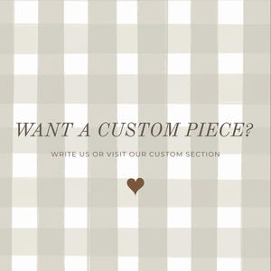 May include: A light beige and white gingham check pattern background with the dark text WANT A CUSTOM PIECE? followed by WRITE US OR VISIT OUR CUSTOM SECTION and a small dark brown heart icon centered at the bottom of the text.