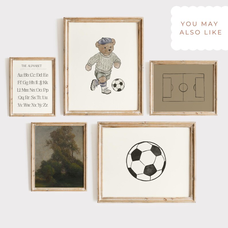 May include: A collection of framed art prints with a neutral color palette. The prints include a soccer ball, a soccer field diagram, a teddy bear playing soccer, an alphabet chart, and a landscape painting. The frames are made of light-colored wood.