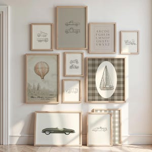 May include: A collection of framed art prints featuring transportation and alphabet themes. The prints include line drawings of a truck, a hot air balloon, motorcycles, a car, a sailboat, and a fire truck. The color palette is neutral with light brown frames.