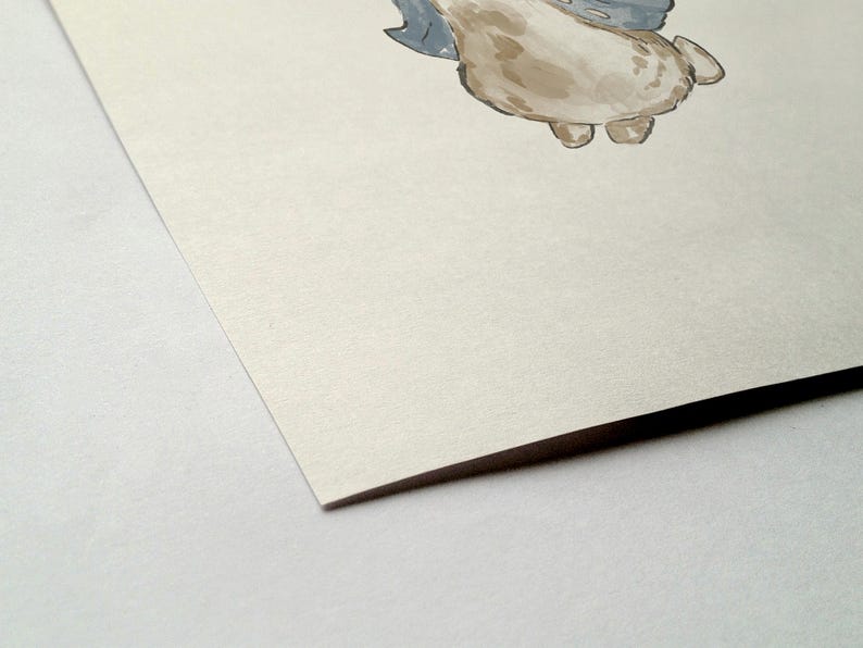 May include: Watercolor illustration of a whimsical creature with a light brown body, gray wings, and small feet. The artwork is on textured, off-white paper, with a corner of the paper visible in the foreground. The style is soft and illustrative.