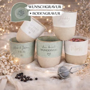 Könnte beinhalten: Fünf Keramikbecher im zweifarbigen Design mit mattem beigen Boden und einem gesprenkelten salbeigrünen oder weißen oberen Bereich. Die Becher sind mit verschiedenen deutschen Schriftzügen und Namen wie Hubby, Mrs. und Maria & Johannes graviert.