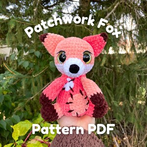 Może przedstawiać: Pluszowa zabawka amigurumi lisa w patchworku z brązowymi akcentami. Zabawka jest trzymana w dłoni, a widoczny jest tekst "Patchwork Fox Pattern PDF".