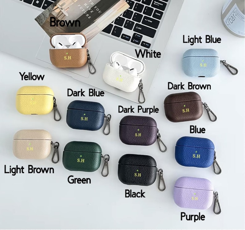 May include: Ten different colored leather cases for Apple AirPods with a gold S.H logo. The colors are yellow, brown, light brown, dark blue, green, black, white, light blue, dark brown, and purple.