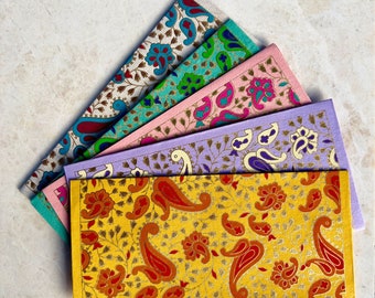 May include: A set of five colorful envelopes with intricate paisley patterns. The envelopes are made of paper and have a variety of colors, including pink, purple, blue, and yellow. The envelopes are decorated with gold accents.