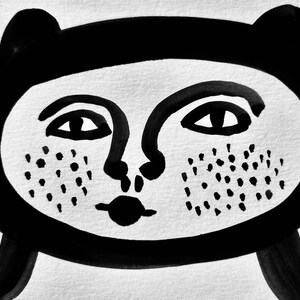 May include: Black and white illustration of a stylized face with large eyes, a small nose, and a wide mouth. The face has a dotted pattern on the cheeks.