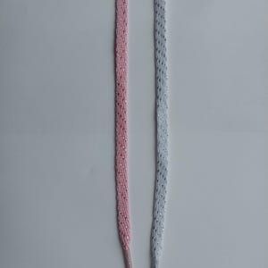 May include: Two shoelaces, one pink and one white, with a silver glitter finish.