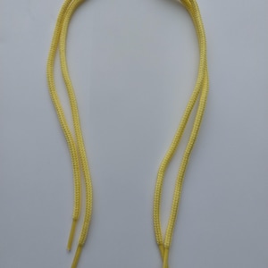 May include: A pair of yellow shoelaces. The laces are made of a woven material and are approximately 40 inches long.