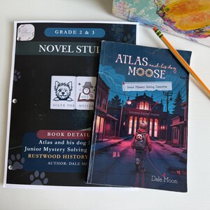 May include: A Novel Study workbook for grades 2 and 3, featuring a black cover with paw prints and the text 'Solve the Mystery', alongside a book titled 'Atlas and his dog Moose' by Dale Moon, depicting a child walking toward a museum, with a pencil.