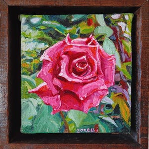 Puede incluir: Una pintura de cerca de una rosa rosa vibrante con hojas verdes. La rosa está en plena floración y los pétalos están curvados hacia adentro. La pintura está enmarcada en un marco de madera oscura.