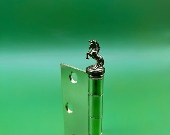 May include: A silver door hinge with a unicorn figurine on top. The unicorn is silver and has a black mane and tail.