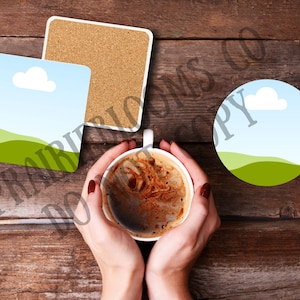 May include: Three coasters with a landscape design featuring a green hill, blue sky, and a white cloud. The coasters are made of ceramic and have a cork backing. A cup of coffee is sitting on a wooden table.