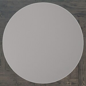 May include: A plain, light grey round table top.